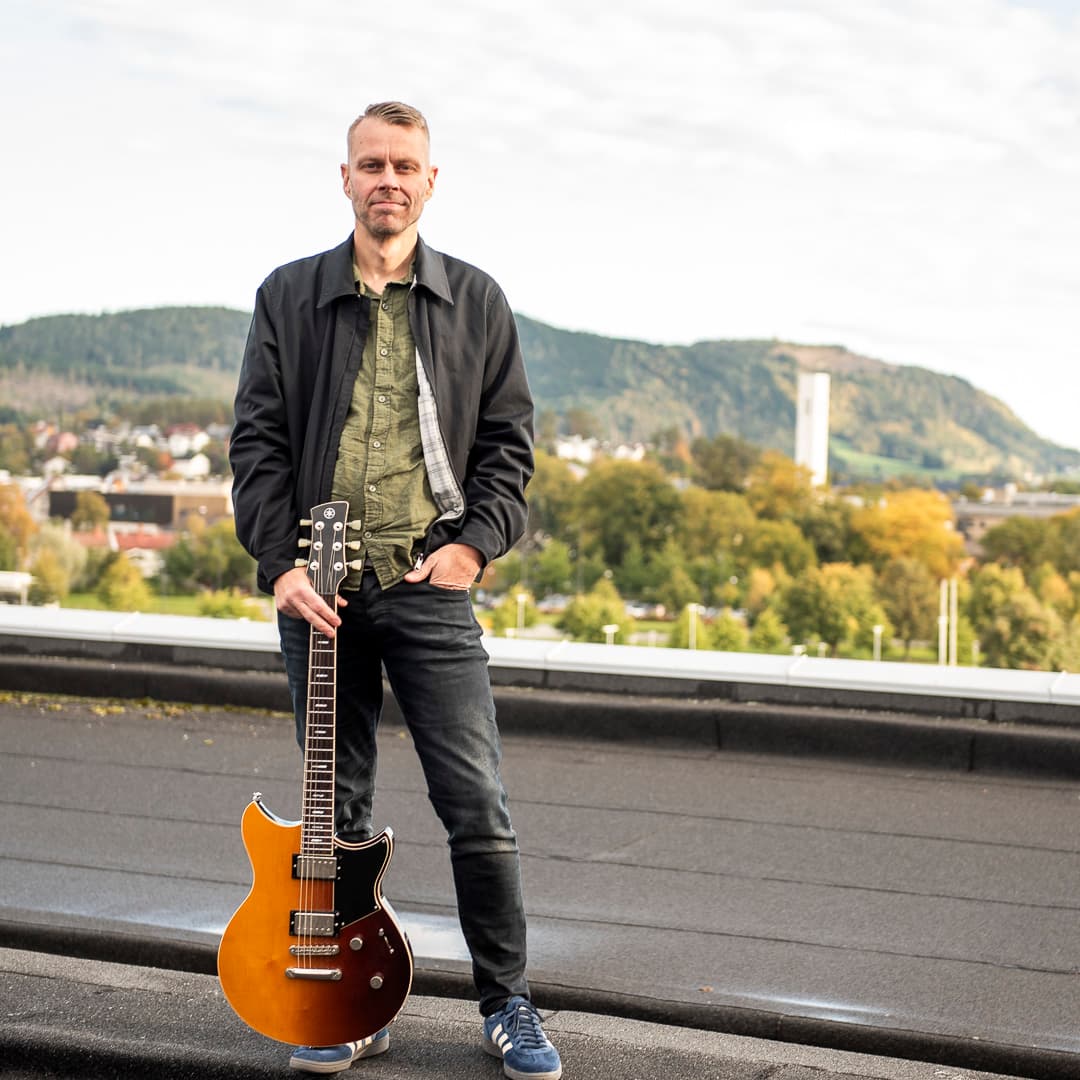 Tommy Sivertsen med gitar Tommy Sivertsen er på fritids musikker og spiller gitar. Her på taket hos NTE med gitar.