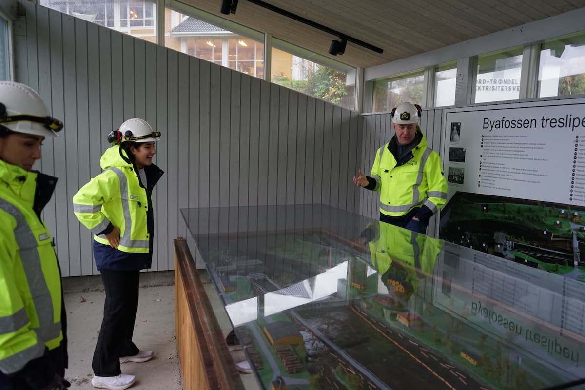 forklaring på byafossen To kvinner og en mann i verneklær ser på en glassplate