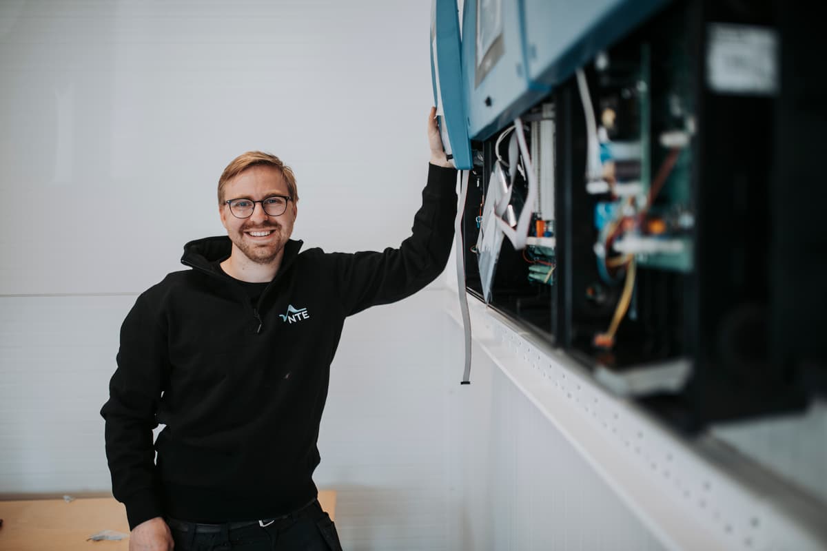 sigurd winge Smilende mannlig elektriker foran skap