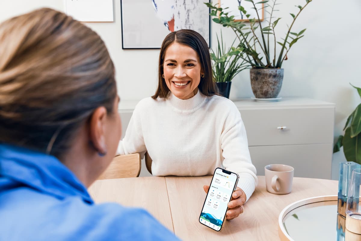 Dame viser en venninne appen Mitt NTE Dame viser frem mobilen