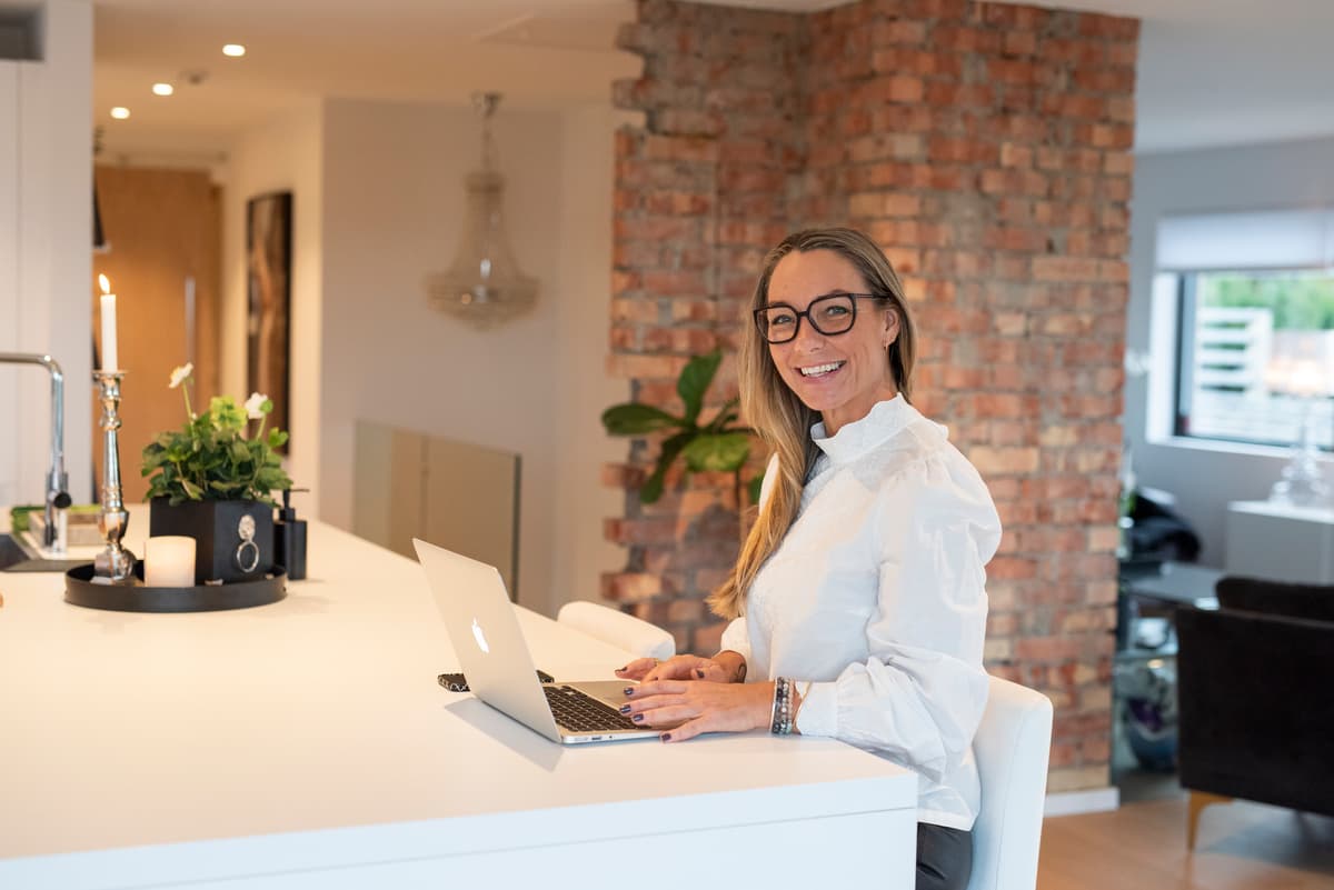 Hjemmekontor Smilende dame sitter foran pc-en