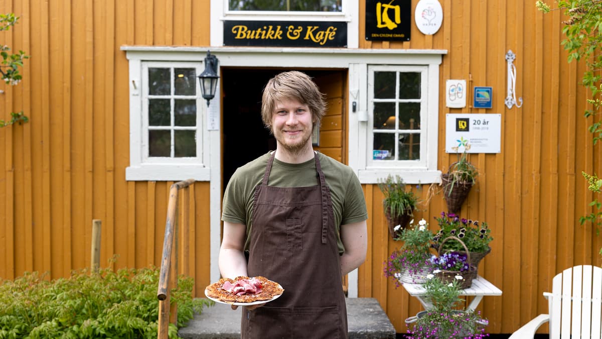 Gulburet Mann med forkle holder en tallerken med en vaffelplate på