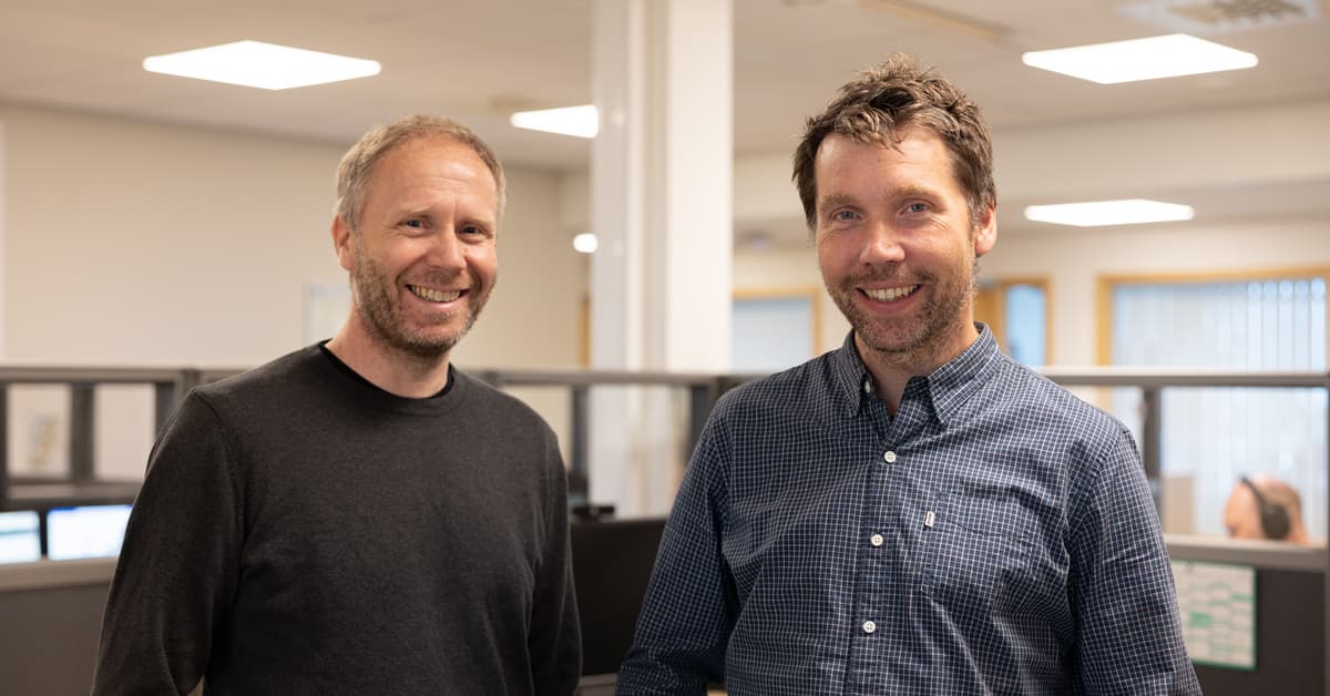ståle og christian To smilende menn i et kontorlandskap