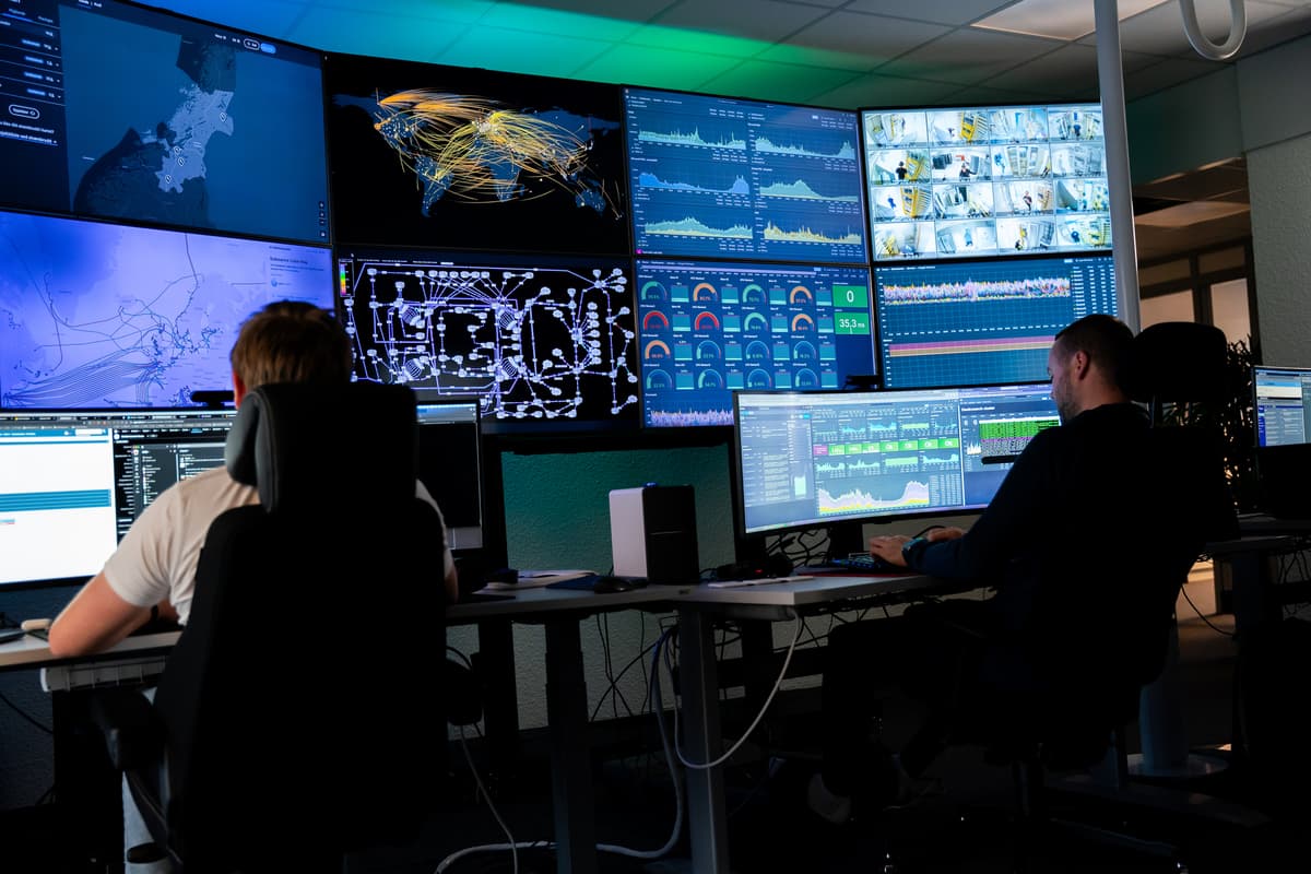 NTE Telekom sørger for høy oppetid NTE Telekom sørger for høy oppetid. Bilde viser to personer som ser på mange pc-skjermer. Disse viser status på fibernettet.