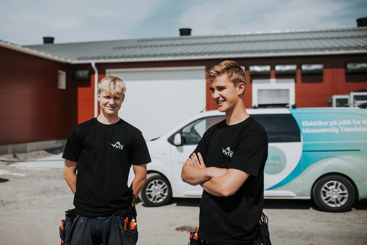 elektrikere foran arbeidsbil To mannlige elektrikere foran en arbeidsbil med NTE-logo