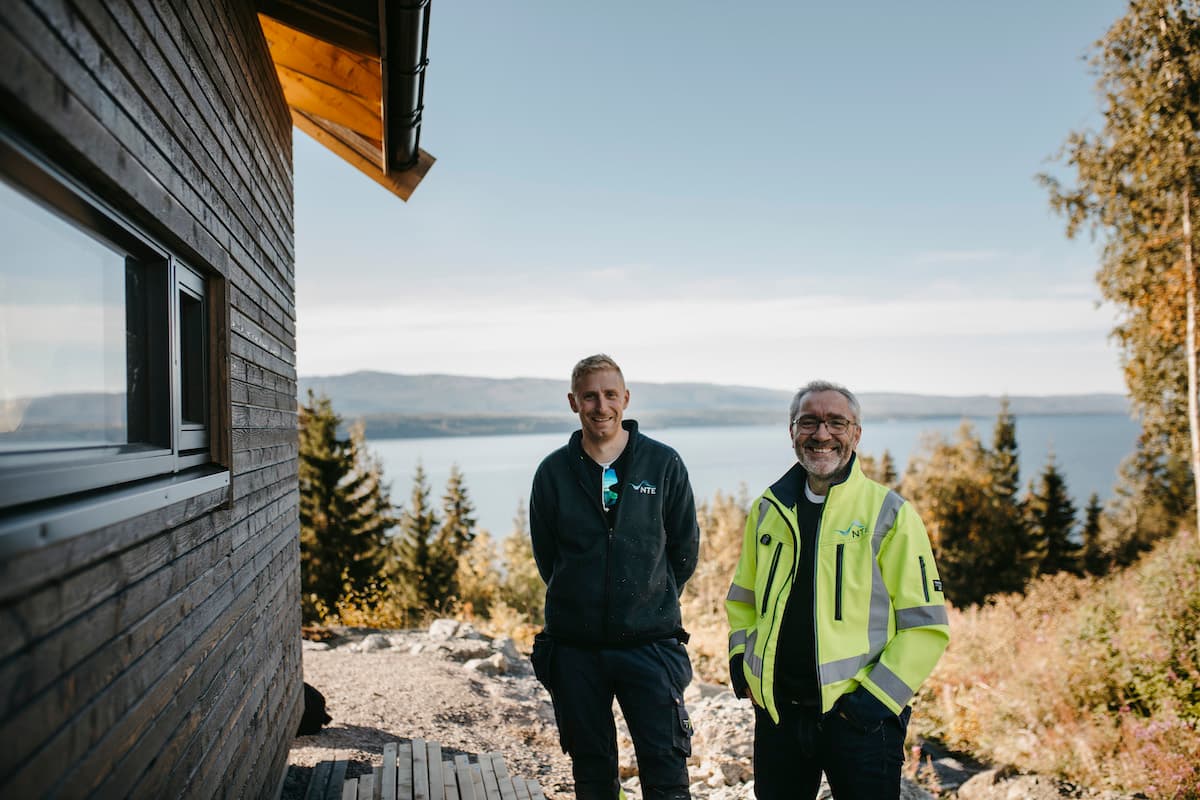 vegar og ketil To smilende menn i arbeidsklær utenfor en hytte
