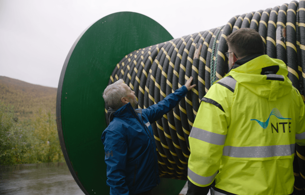 Ballangen Sjøfarm Sjøkabel To menn ser på en trommel med en lang elektrisk kabel på