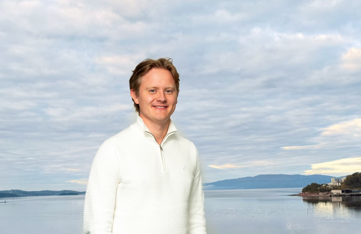 Hans Olav Bruce på taket på NTEs hovedkontor på Steinkjer. Han ser i kamera. I bakgrunn oversikt over fjord. Hans Olav Bruce på taket på NTEs hovedkontor på Steinkjer. Han ser i kamera. I bakgrunn oversikt over fjord.