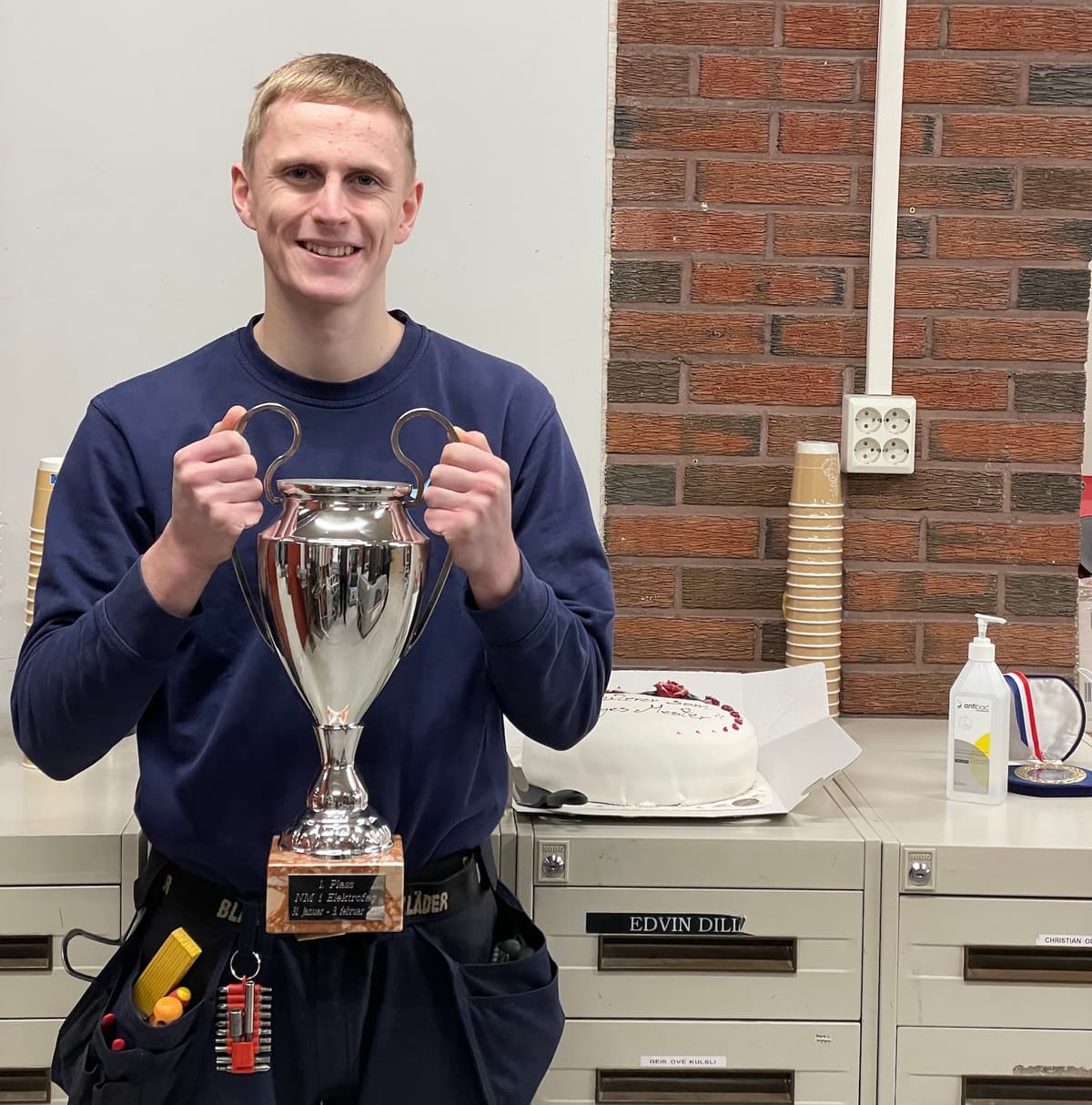 Ung mann holder opp en stor pokal Ung mann holder opp en stor pokal